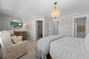 Summerville apartment for rent - a white bedroom with a bed and a chair and a chandelier
