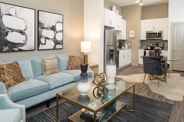 Austin apartment for rent - A modern living room with a blue couch and a coffee table with a glass top.