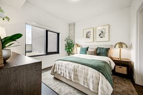 Nashville apartment for rent - A bedroom with a bed, nightstand, and a potted plant.