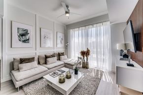 Hutto apartment for rent - A modern living room with a white sofa, coffee table, and a ceiling fan.