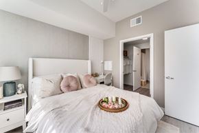 Hutto apartment for rent - A bedroom with a large bed and a tray of fruit on the pillow.