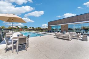 Hutto apartment for rent - A poolside area with chairs and an umbrella.