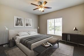 Lawrence apartment for rent - A bedroom with a large bed and a ceiling fan.
