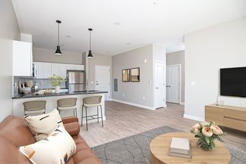 Cranberry Township apartment for rent - A modern living room with a brown leather couch and a wooden coffee table.