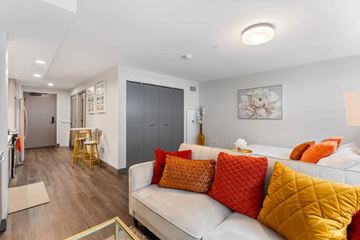 Chicago apartment for rent - A living room with a white couch and orange pillows.