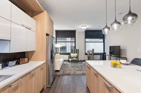 Chicago apartment for rent - A modern kitchen with a refrigerator, sink, and a dining area with chairs and a table.