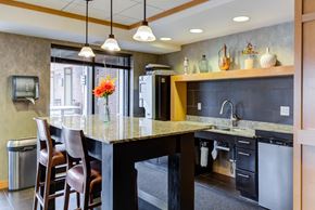 Osseo apartment for rent - A kitchen with a marble countertop and a dining table with chairs.
