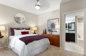 Woodlands apartment for rent - A bedroom with a white bed and a round mirror on the wall.