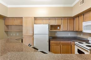 Woodlands apartment for rent - A kitchen with wooden cabinets and a white refrigerator.