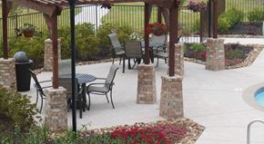 Fort Worth apartment for rent - A patio with a table and chairs under a pergola.