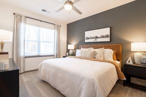 Greensboro apartment for rent - A bedroom with a large bed and a ceiling fan.