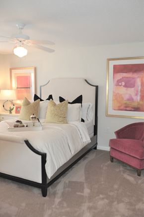 High Point apartment for rent - A bedroom with a white bed and a pink chair.