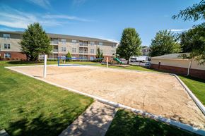 Anderson apartment for rent - A playground with a sandbox and a swing set in front of a building.