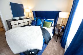 Anderson apartment for rent - A bedroom with a bed, a dresser, and a chair.