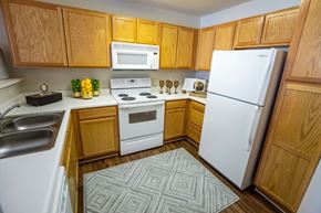 Anderson apartment for rent - A kitchen with wooden cabinets and white appliances.