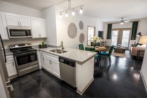 Greensboro apartment for rent - A kitchen with white cabinets and black countertops.