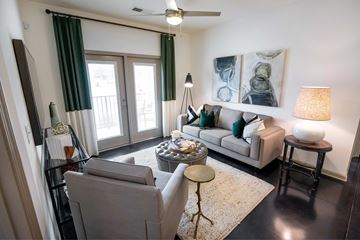 Greensboro apartment for rent - A living room with a grey couch, a coffee table, and a painting on the wall.