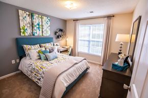 Charlotte apartment for rent - A bedroom with a large bed and a window with curtains.