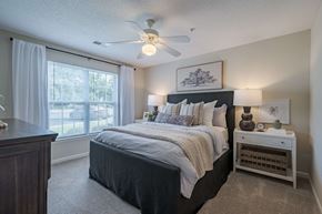 Goldsboro apartment for rent - A bedroom with a large bed and a ceiling fan.
