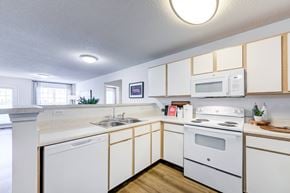 Fayetteville apartment for rent - A white kitchen with wooden cabinets and a white stove.