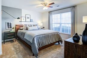 Fayetteville apartment for rent - A bedroom with a large bed and a ceiling fan.