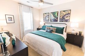 Fort Mill apartment for rent - A bedroom with a large bed and a ceiling fan.