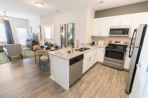 Fort Mill apartment for rent - A kitchen with white cabinets and a wooden floor.