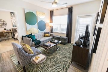 Fort Mill apartment for rent - A living room with a grey sofa and a patterned rug.