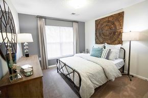 Wilson apartment for rent - A bedroom with a large bed and a wooden dresser.