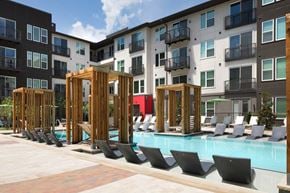 Dallas apartment for rent - A pool area with chairs and a wooden structure.