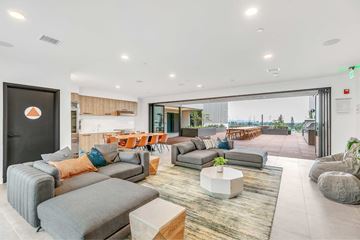 Pasadena apartment for rent - A modern living room with grey and orange couches and a large window.