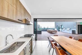 Pasadena apartment for rent - A modern kitchen with a long wooden table and chairs.