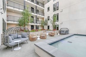 Pasadena apartment for rent - A modern outdoor seating area with a pool and a building in the background.