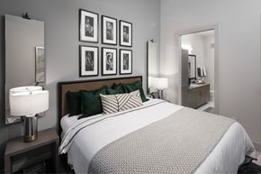 Frisco apartment for rent - A bedroom with a large bed and a mirror on the wall.