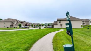 Belton apartment for rent - A green signpost stands in a grassy area with a path leading to a residential area.