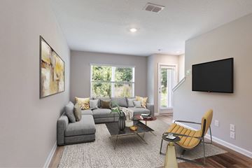 Jacksonville apartment for rent - A living room with a grey couch, a yellow chair, and a painting on the wall.