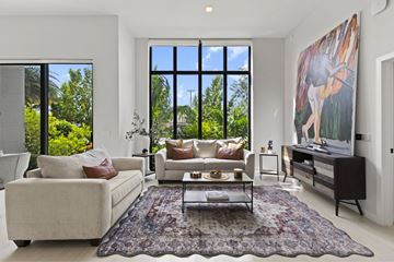 Dania Beach apartment for rent - A living room with a large rug and a painting of a deer on the wall.