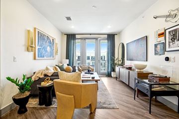 Austin apartment for rent - A living room with a yellow chair and a black table.