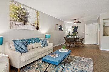 Burnsville apartment for rent - A living room with a white couch, a blue coffee table, and a painting on the wall.