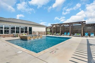 Abilene apartment for rent - A pool with a water slide and a building behind it.