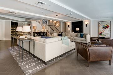 Charlotte apartment for rent - A living room with a white couch and a brown leather ottoman.
