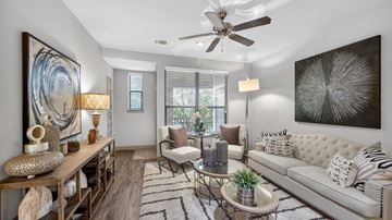 Allen apartment for rent - A living room with a white couch, a wooden table, and a large painting on the wall.