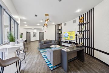 Dallas apartment for rent - A modern living room with a grey sofa and a white dining table.