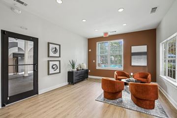 Kennesaw apartment for rent - A living room with a brown sofa and two orange chairs.