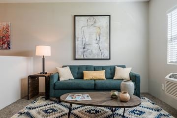 Lawrence apartment for rent - A living room with a green couch, a coffee table, and a painting on the wall.