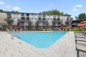 Atlanta apartment for rent - A large swimming pool in front of a multi-story apartment building.
