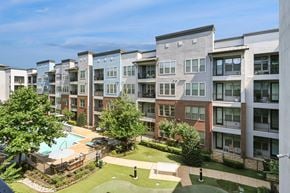 Carrollton apartment for rent - Apartment complex with a pool and green lawn.