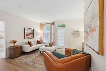 Raleigh apartment for rent - A living room with a brown leather chair and a white sofa.
