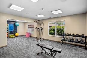 Indianapolis apartment for rent - A gym room with a bench, weights, and exercise equipment.