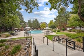 Littleton apartment for rent - A pool surrounded by trees and a stone wall.